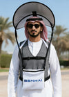 Person wearing a backpack with a canopy, standing outdoors with palm trees in the background