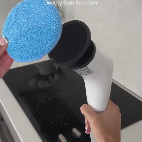 Handheld cordless electric spin scrubber cleaning a stovetop